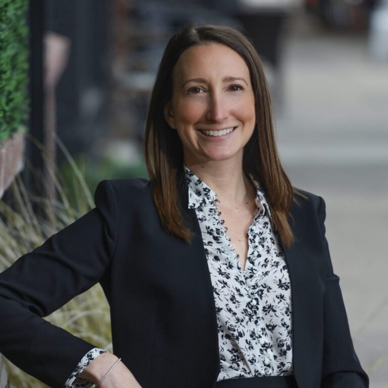 Branding portrait of a professional woman in a dark blazer outdoors