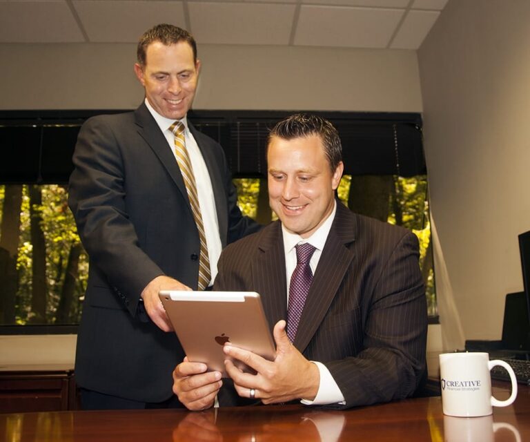 Two executives reviewing a tablet at a conference table