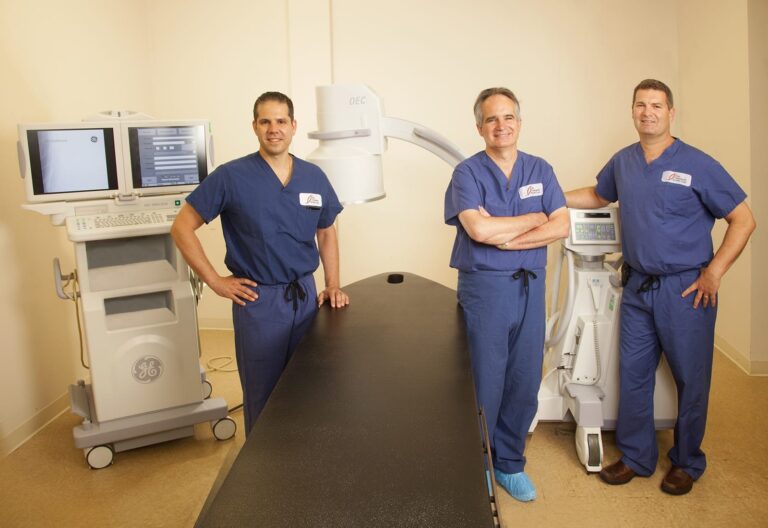 Surgical team in scrubs beside medical equipment